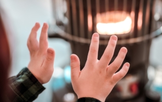 child warming hands near pellet stove