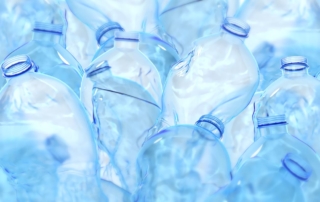 A pile of clear, empty plastic water bottles
